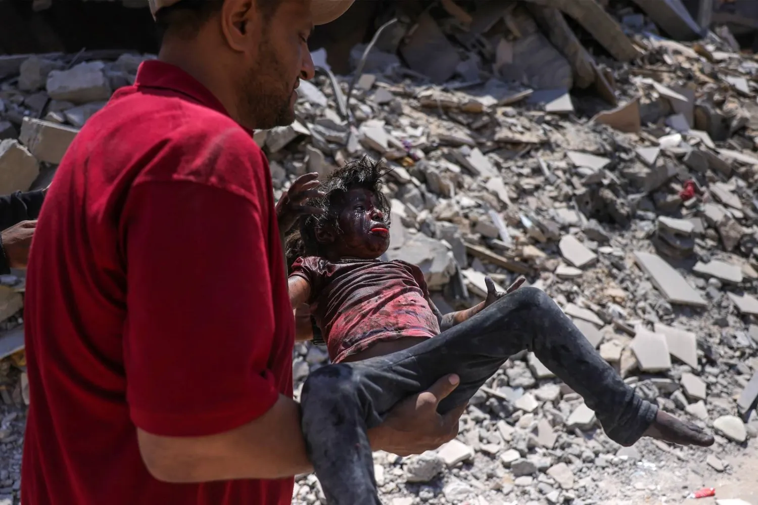 فلسطيني يحمل طفلة انتُشلت من بين أنقاض منزل استهدفته غارة إسرائيلية على غرب جباليا شمال غزة (أ.ف.ب)