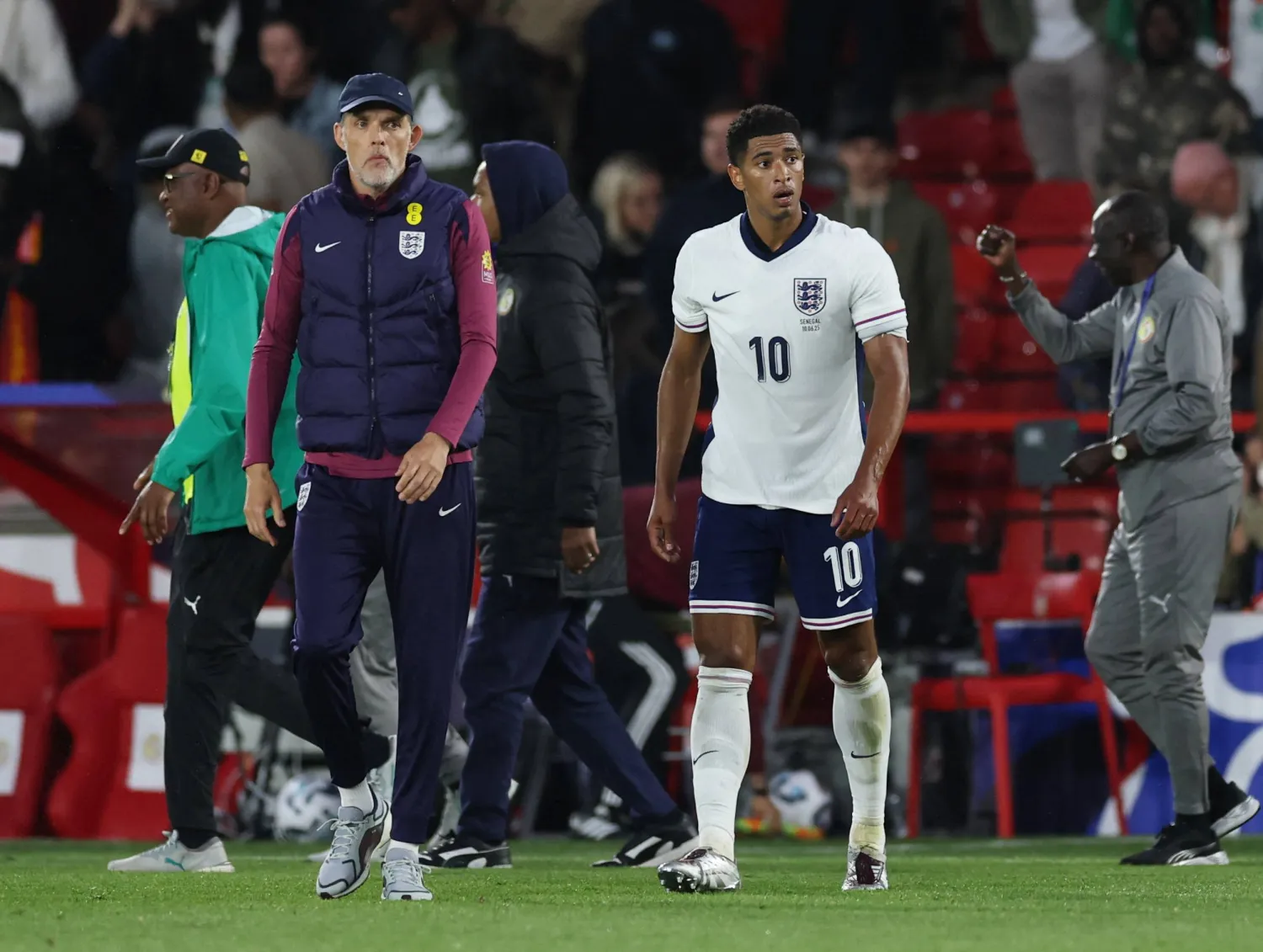 مدرب المنتخب الإنجليزي توماس توخيل ولاعبه جود بلينغهام بعد الهزيمة من السنغال (رويترز)