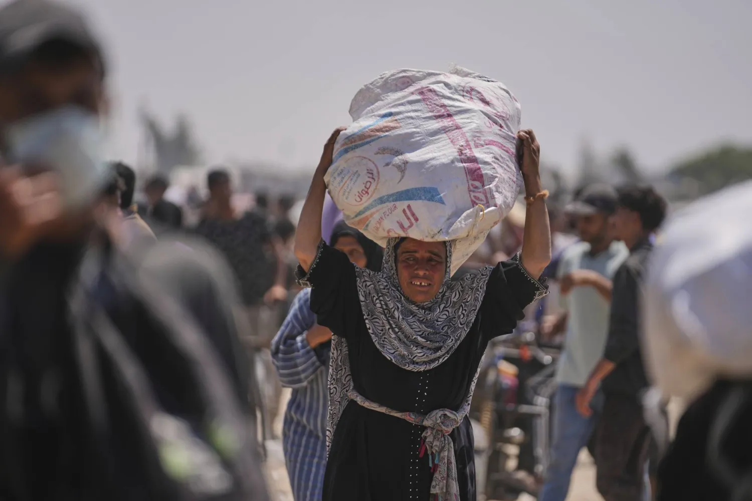 امرأة فلسطينية تحمل حقيبة تحتوي على طعام ومساعدات إنسانية قدمتها «مؤسسة غزة الإنسانية» وهي منظمة مدعومة من الولايات المتحدة في رفح (أ.ب)