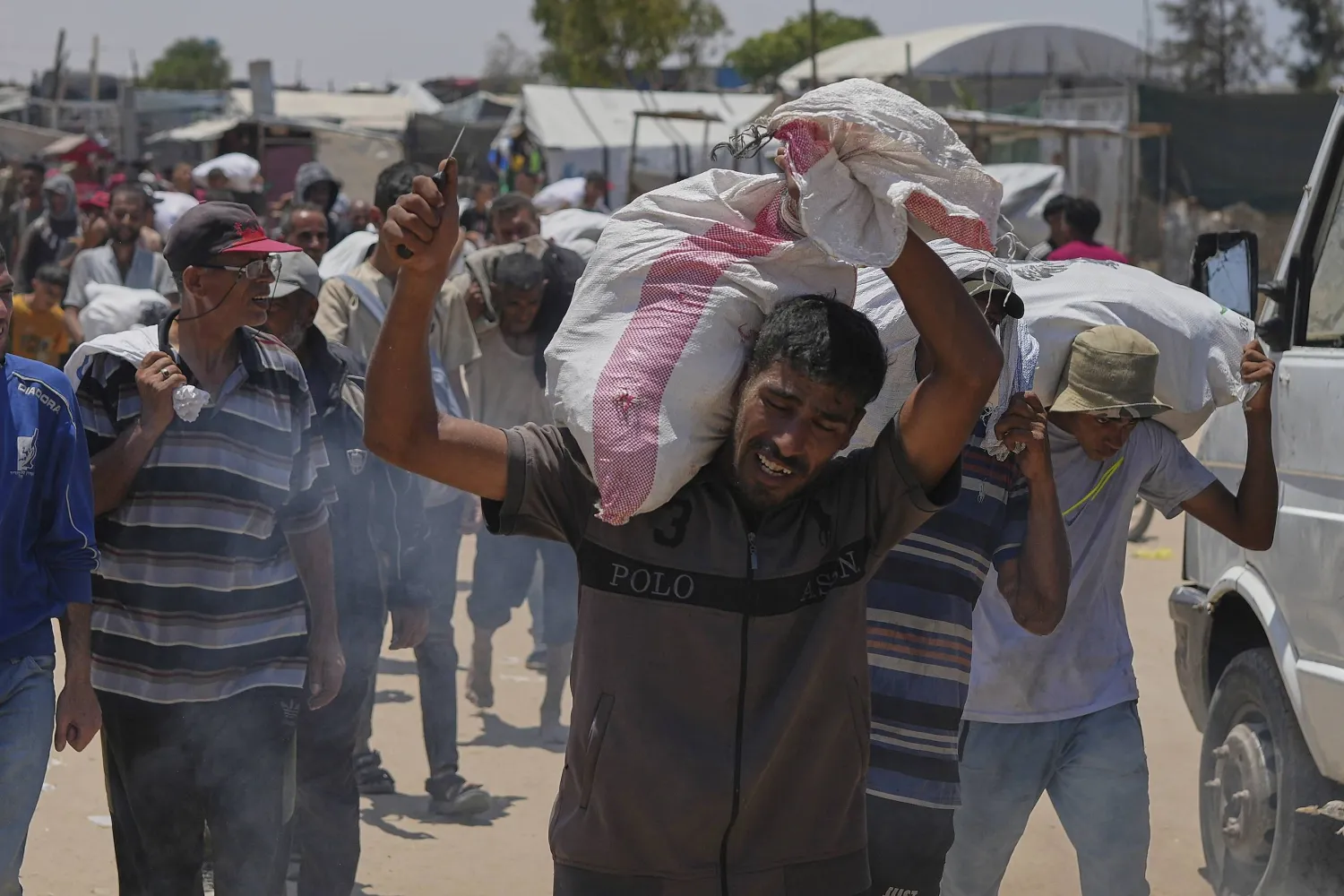 فلسطينيون يحملون مساعدات إنسانية في رفح بجنوب قطاع غزة (أ.ب)