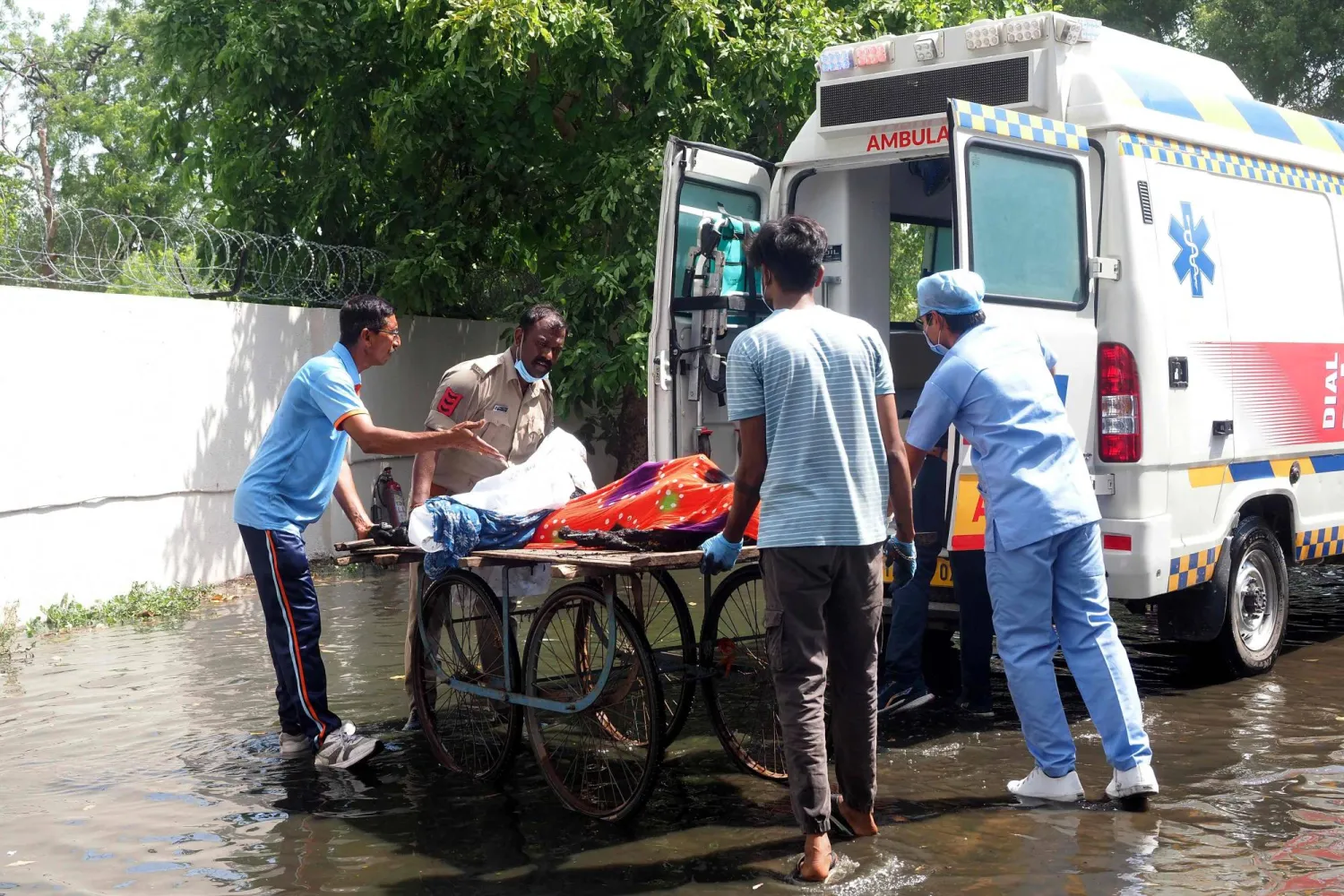 شرطي ومسعفون ينقلون ضحايا حادث تحطم طائرة الخطوط الجوية الهندية إلى سيارة إسعاف (أ.ف.ب)