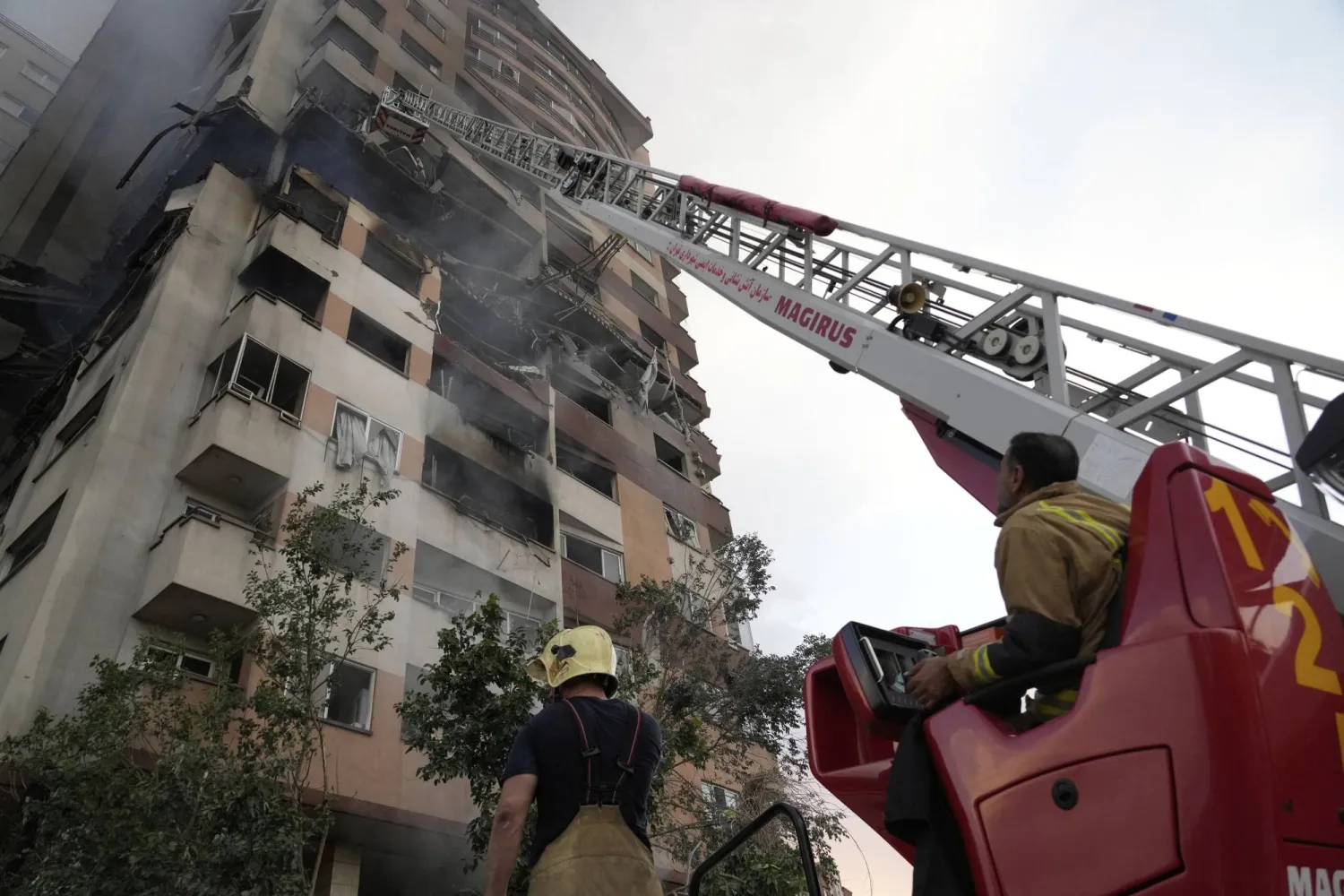 رجال إطفاء يعملون في موقع انفجار في مجمع سكني شمال طهران جراء ضربات إسرائيلية (ا.ب)