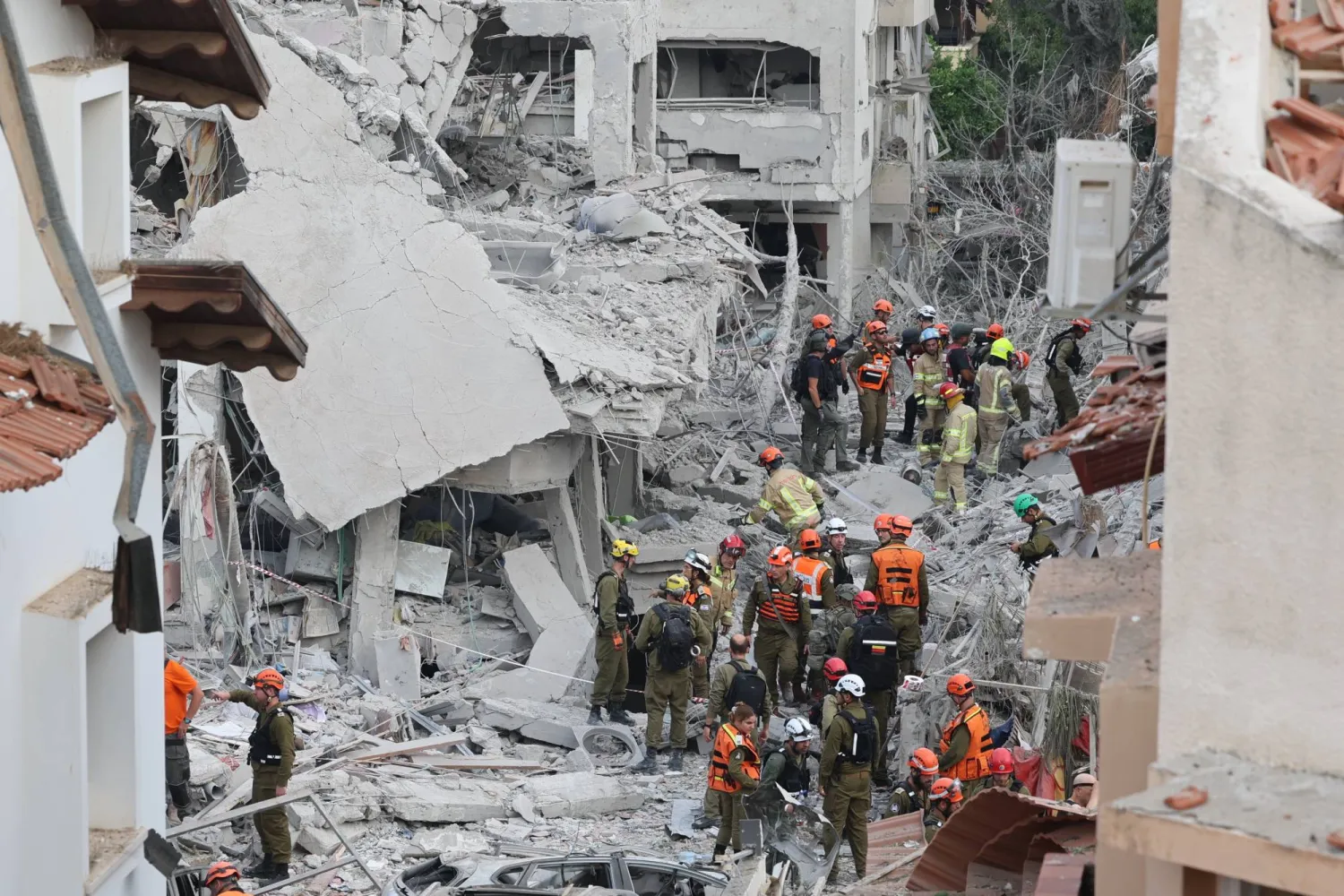 فرق الإنقاذ الإسرائيلية تعمل وسط الدمار الذي خلفته الصواريخ الإيرانية بالقرب من تل أبيب (إ.ب.أ)