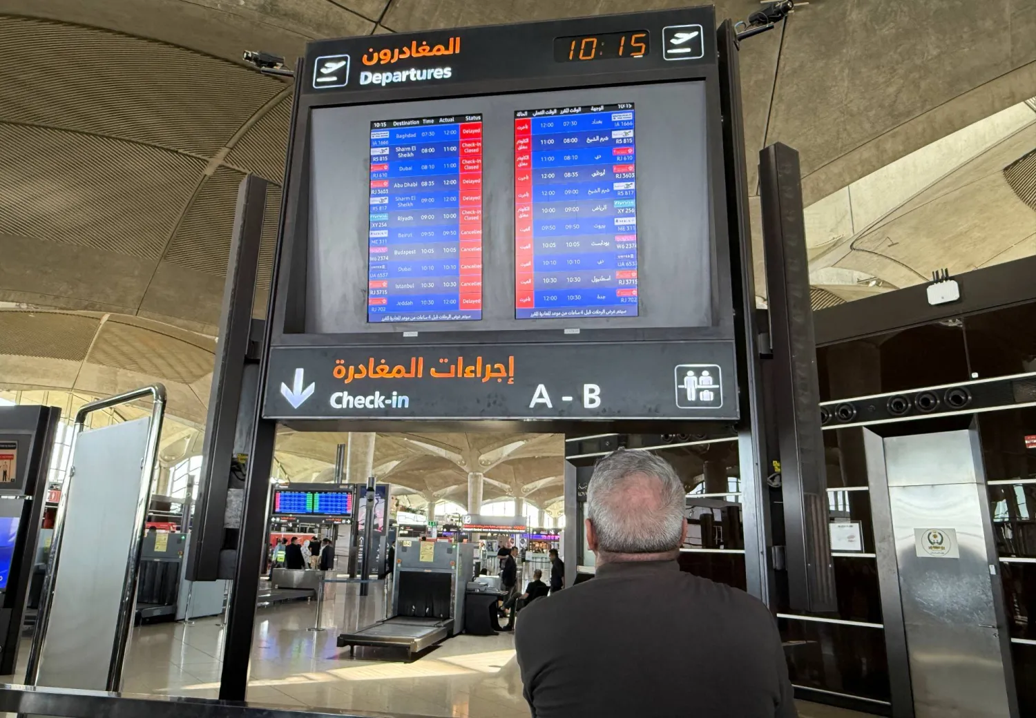 شاشة تعرض معلومات الرحلات الجوية المتأخرة والملغاة في مطار الملكة علياء الدولي في عمان (رويترز)