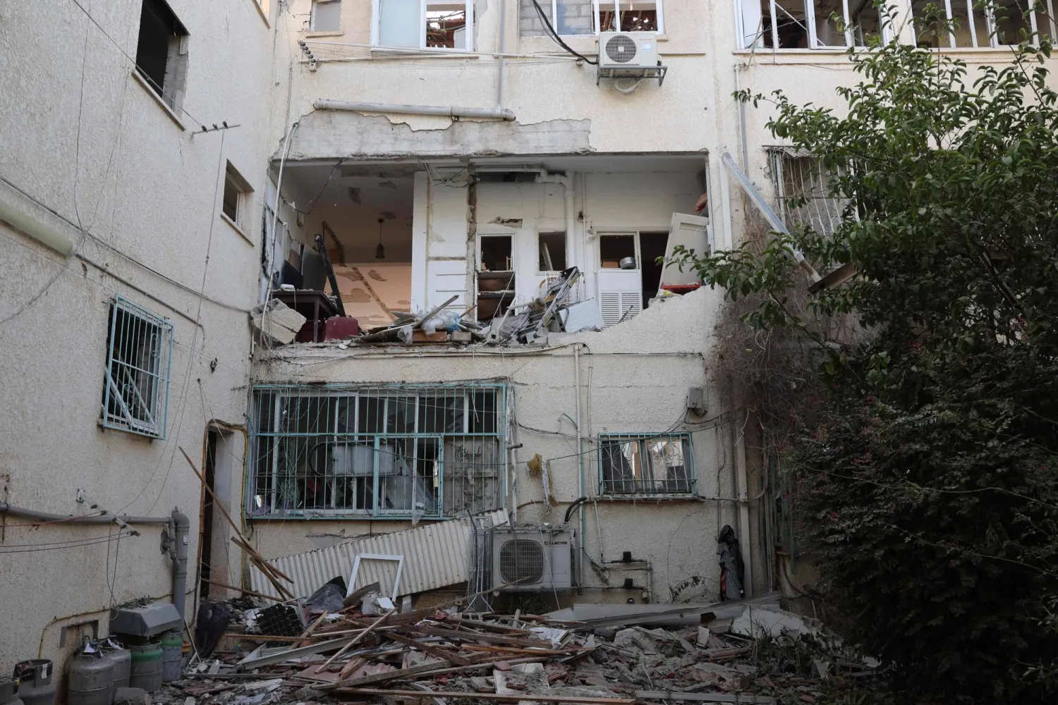 مبنى متضرر في موقع أصيب بصاروخ أطلق من إيران بالقرب من تل أبيب (أ.ف.ب)