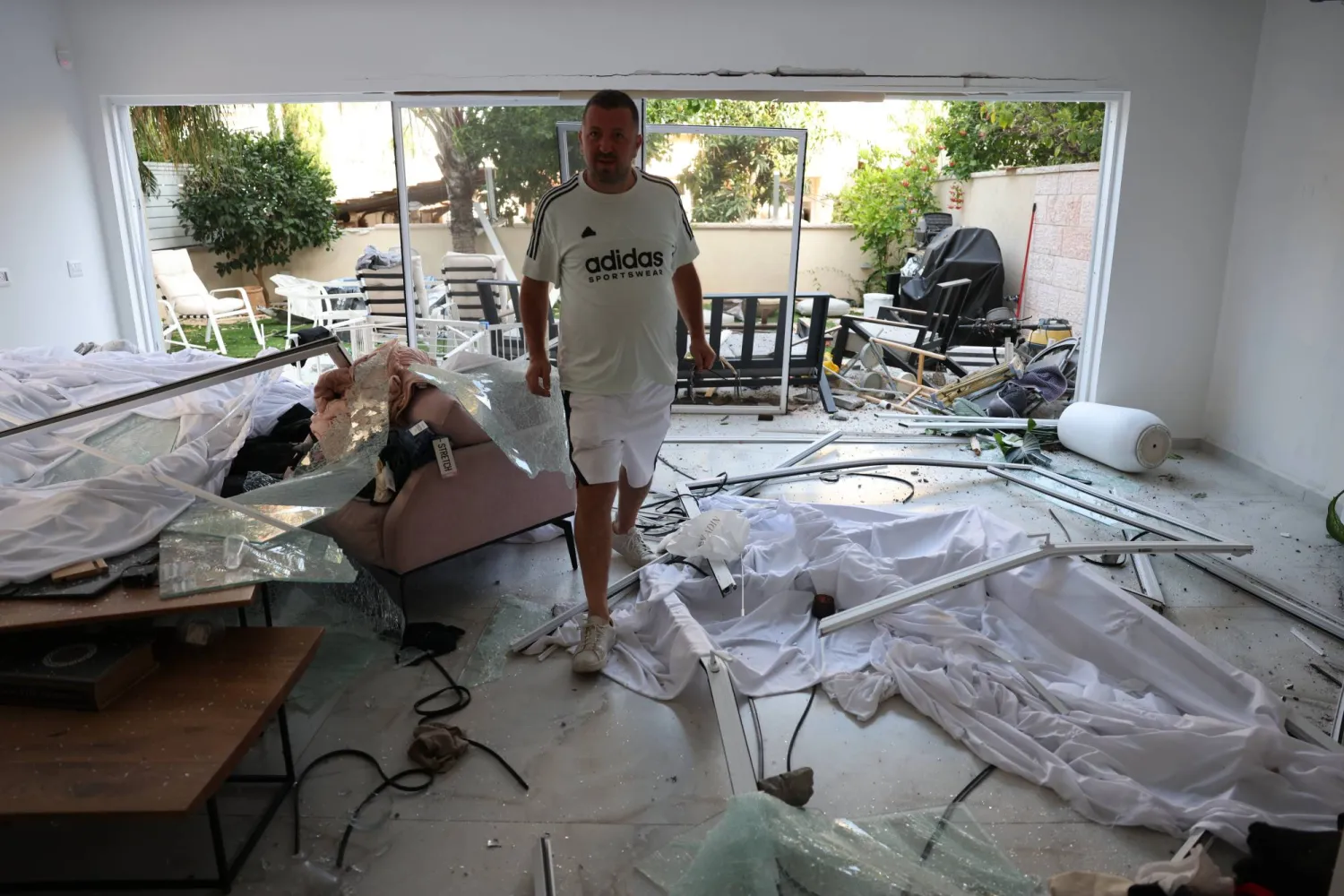 رجل يتفقد الأضرار داخل منزله الذي تعرض لقصف إيراني في ريشون لتسيون بإسرائيل (إ.ب.أ)
