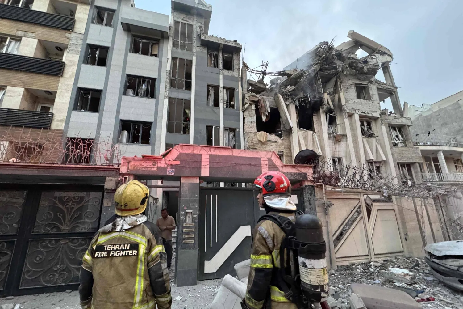 المستجيبون الأوائل يعملون خارج مبنى تعرض لغارة إسرائيلية في طهران (أ.ف.ب)