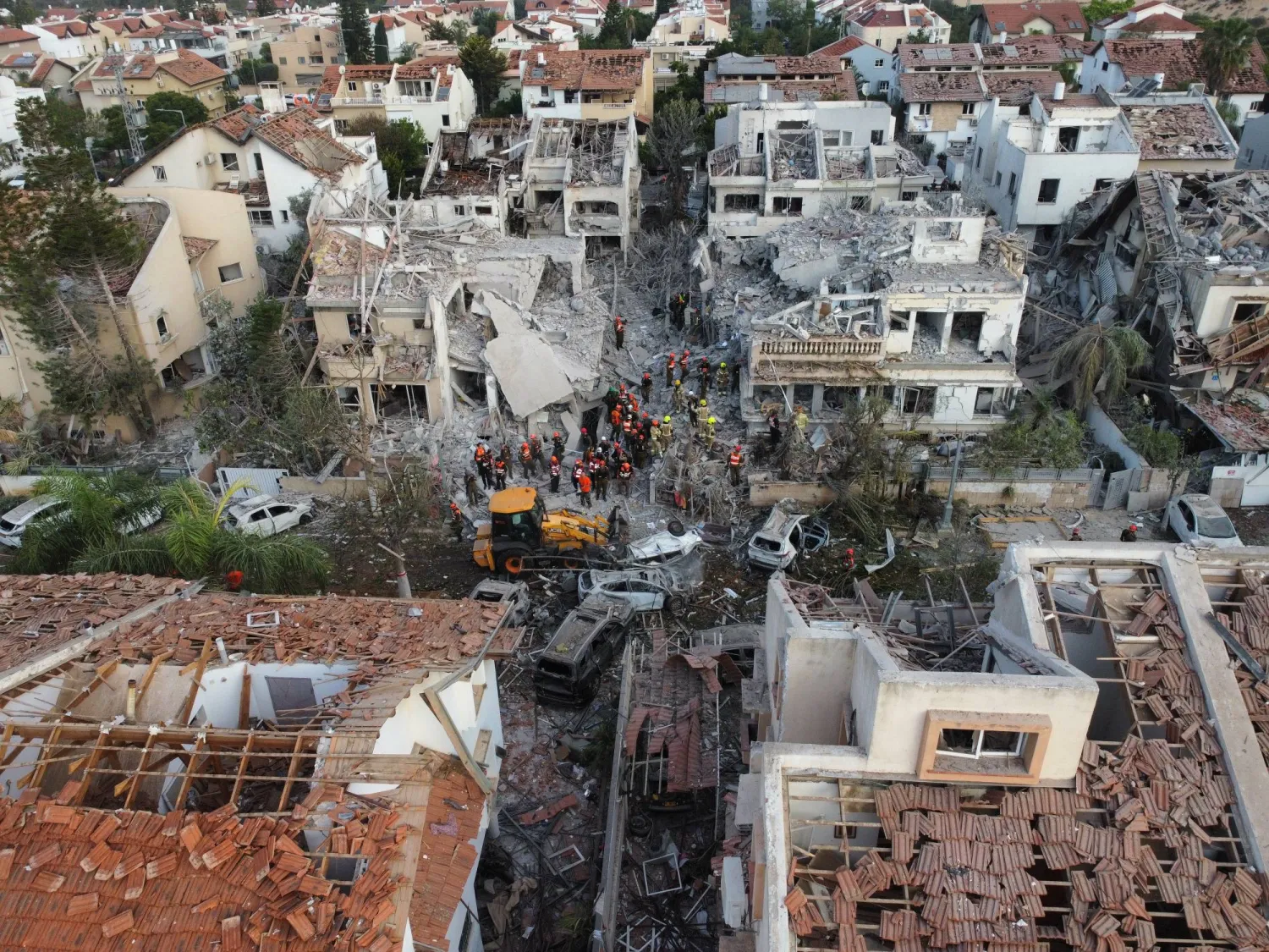 فرق الإنقاذ الإسرائيلية تعمل في موقع سقوط صاروخ باليستي إيراني على مبان سكنية في ريشون لتسيون قرب تل أبيب (إ.ب.أ)