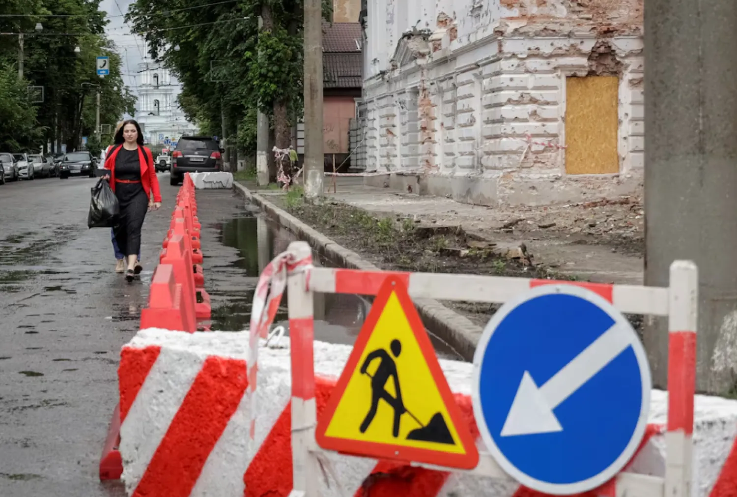 A resident walks at a street near a building damaged by Russian missile strikes, amid Russia's attack on Ukraine, in Sumy, Ukraine June 13, 2025. REUTERS/Sofiia Gatilova 