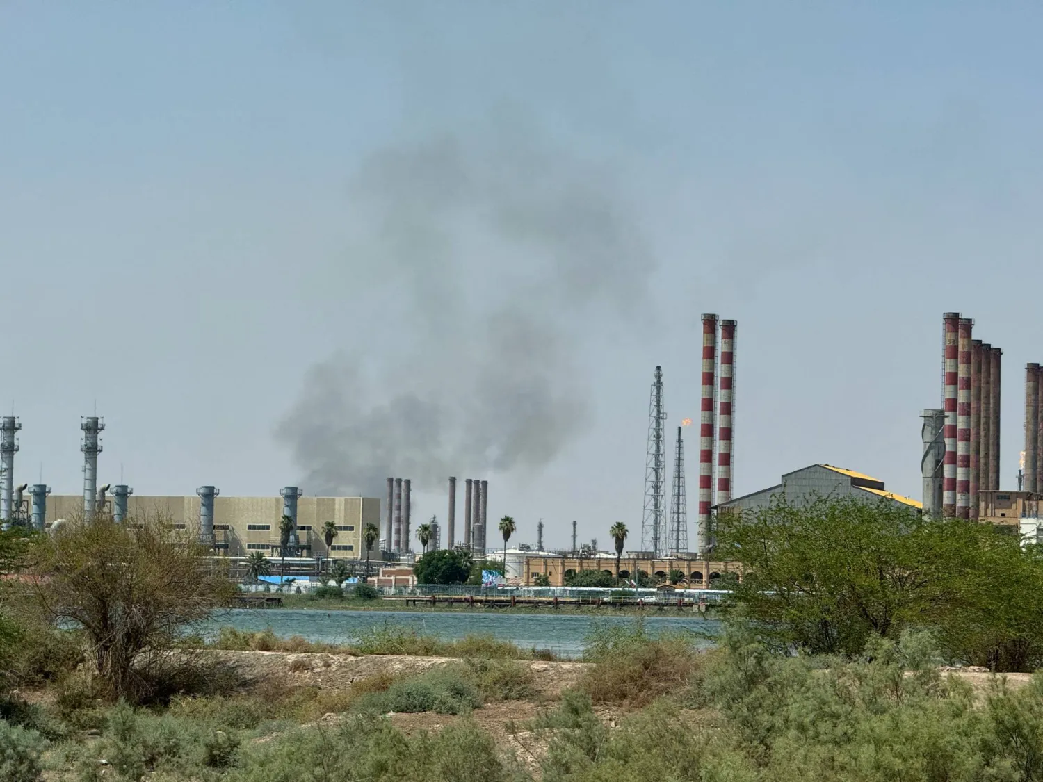 تصاعد الدخان قرب مصفاة عبادان الإيرانية يوم 14 يونيو 2025 (رويترز)