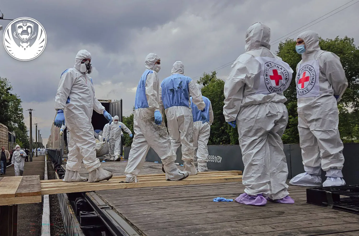 صورة منشورة في 14 يونيو 2025 تظهر موظفين من اللجنة الدولية للصليب الأحمر وهم ينزلون ما يقولون إنها جثث مواطنين أوكرانيين منهم أفراد عسكريون أعادتهم روسيا... في مكان غير معلوم في أوكرانيا (أ.ف.ب)