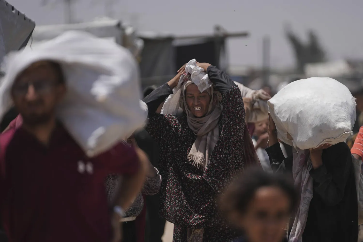 فلسطينيون يحملون مساعدات غذائية من مؤسسة مدعومة أميركياً في رفح جنوب غزة يوم (أ.ب)