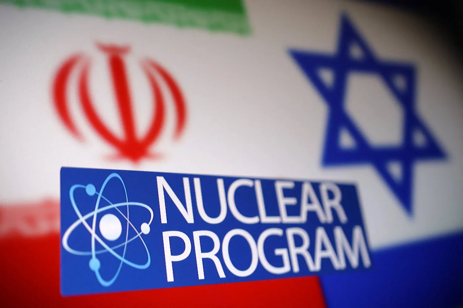 صورة توضيحية ملتقطة في 16 يونيو 2025 تظهر العلمين الإيراني والإسرائيلي خلف رمز الذرة وعبارة «البرنامج النووي» (رويترز) 