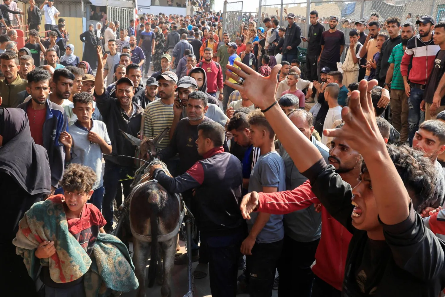 حزن ووجوم عند مستشفى ناصر في خان يونس بجنوب قطاع غزة حيث نُقل قتلى وجرحى فلسطينيون سقطوا بنيران إسرائيلية بينما كانوا ينتظرون مساعدات إنسانية (رويترز)