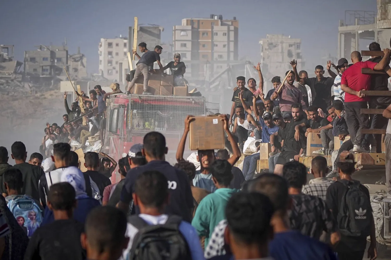 فلسطينيون يستقلون شاحنة محملة بالطعام والمساعدات الإنسانية من برنامج الغذاء العالمي بعد وصولها إلى شمال قطاع غزة (أ.ب)