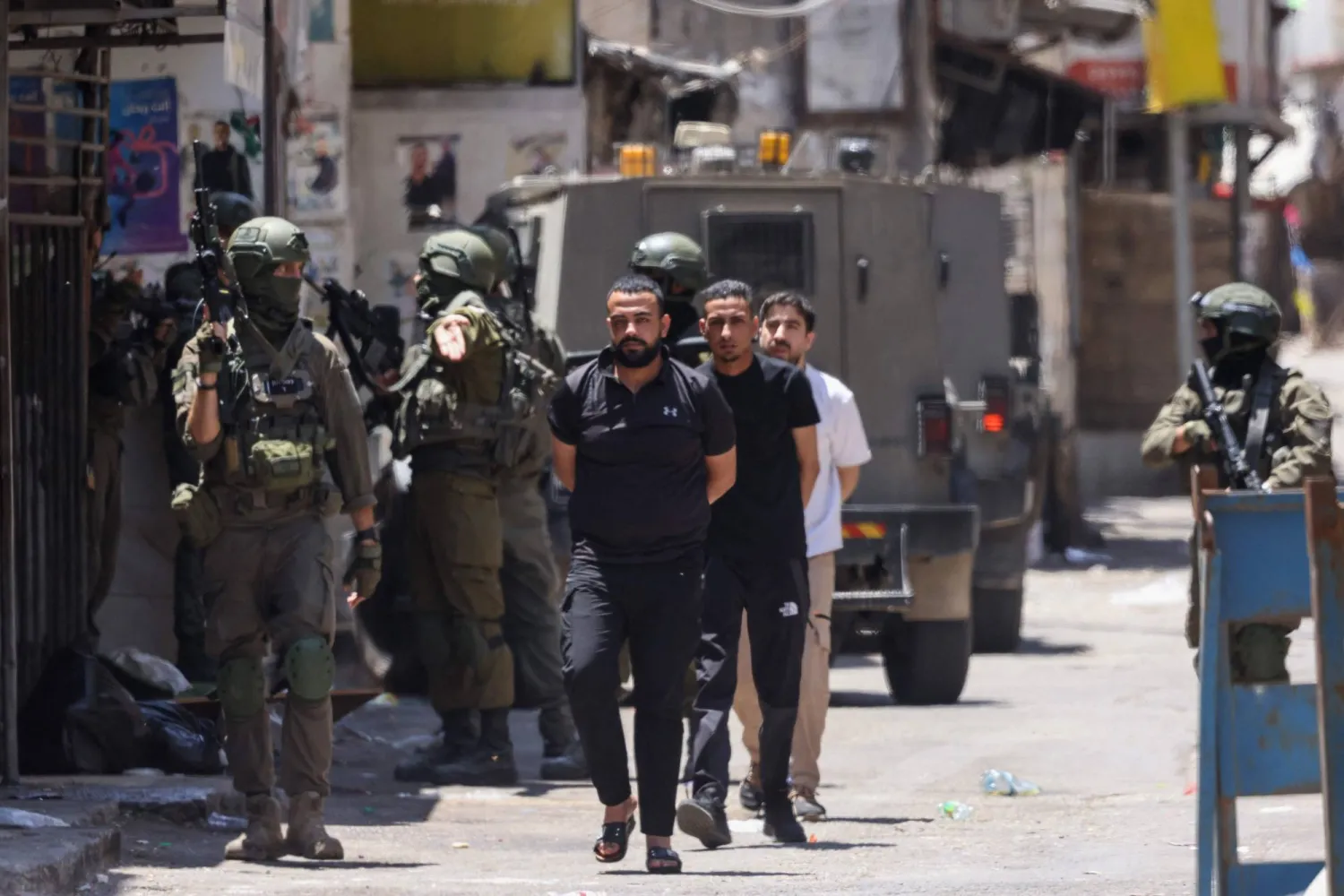 جنود إسرائيليون يعتقلون فلسطينيين خلال مداهمة مخيم بلاطة للاجئين شرقي مدينة نابلس في الضفة الغربية يوم الأربعاء (أ.ف.ب)