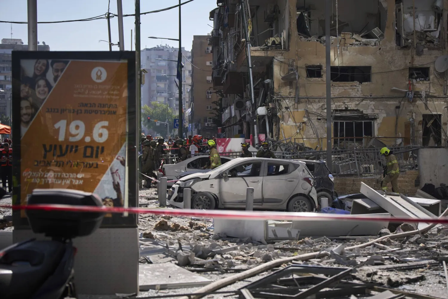 عمال الإنقاذ والعسكريون يتفقدون موقع إصابة مباشرة من ضربة صاروخية إيرانية في رامات غان (أ.ب)