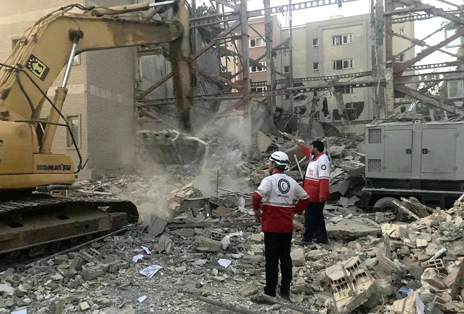 صورة ملتقَطة في 19 يونيو 2025 تُظهر أعضاء فِرق الإنقاذ وهم يقومون بإزالة الأنقاض من مبنى دُمر خلال هجوم إسرائيلي بطهران (أ.ف.ب)