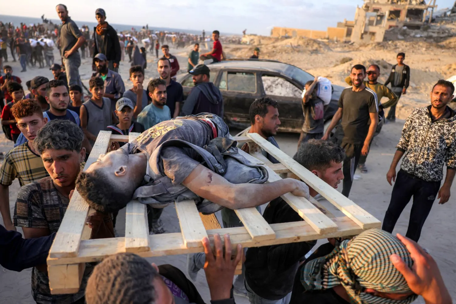 فلسطينيون يحملون جثماناً على منصة نقالة قُتل في قصف إسرائيلي غرب جباليا شمال قطاع غزة (أ.ف.ب)