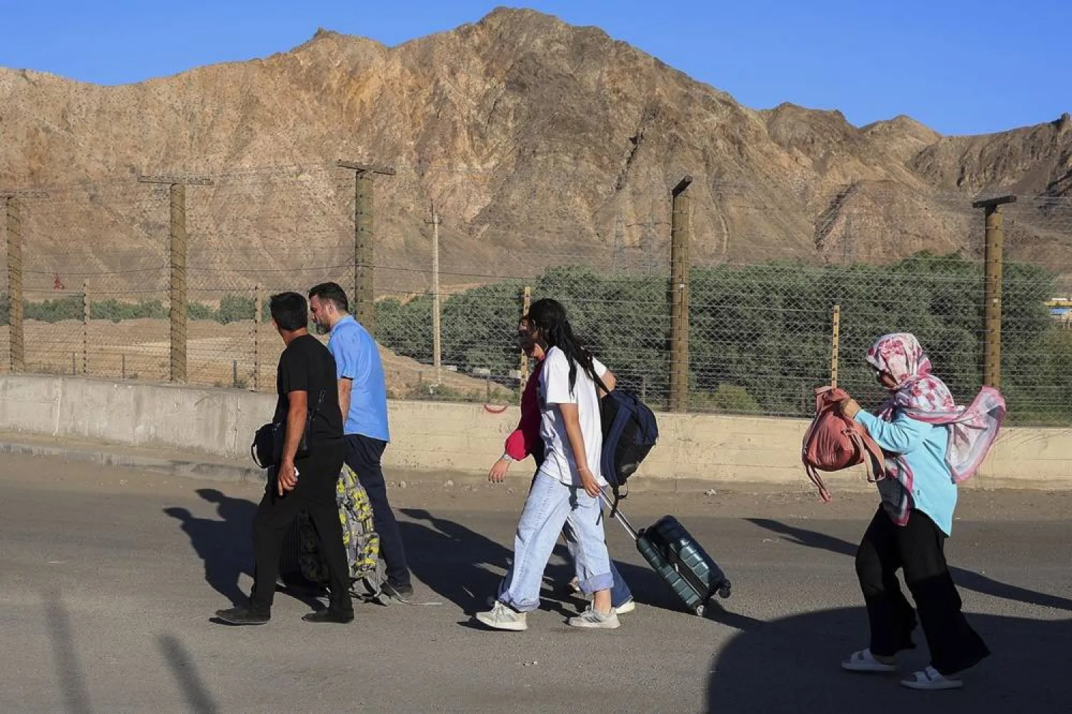 People, mostly Iranians, who left the country due to Israeli strikes on Iran, walk at the border crossing point on Armenia-Iran border near Agarak village in the Meghri Municipality of the Syunik Province in southern Armenia, Thursday, June 19, 2025. (AP)