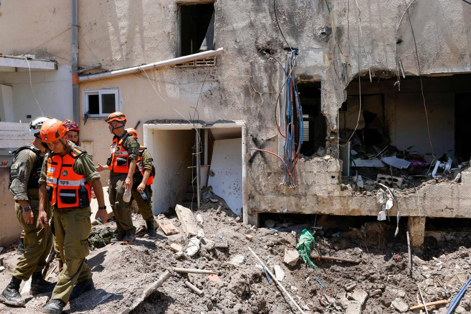 جنود إسرائيليون وفرق إسعاف أولية يتفقدون الأضرار التي لحقت بمبنى جراء غارة إيرانية على إسرائيل - 21 يونيو 2025 (أ.ف.ب)