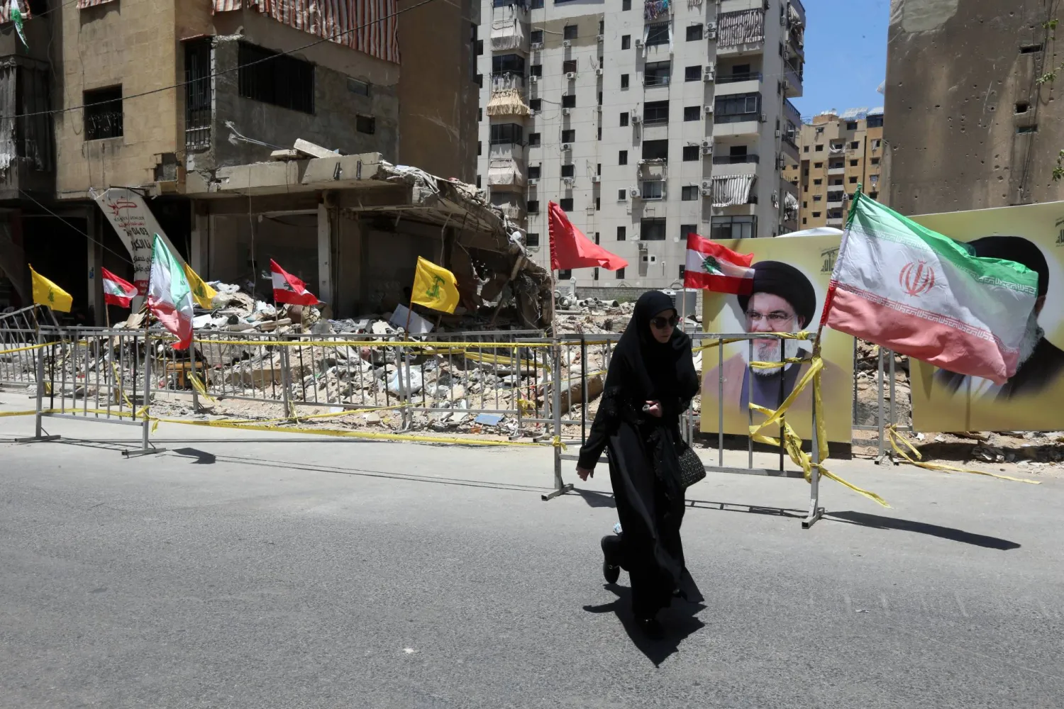 مناصرة لـ«حزب الله» تسير قرب موقع تعرض لقصف إسرائيلي سابق في الضاحية الجنوبية لبيروت خلال مظاهرة داعمة لإيران... الجمعة (إ.ب.أ)