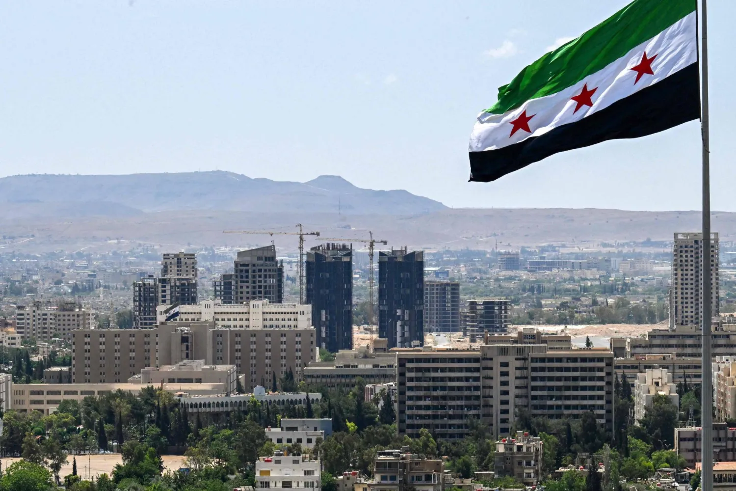 علم سوري كبير فوق «حديقة تشرين» بدمشق 2025 (أ.ف.ب)