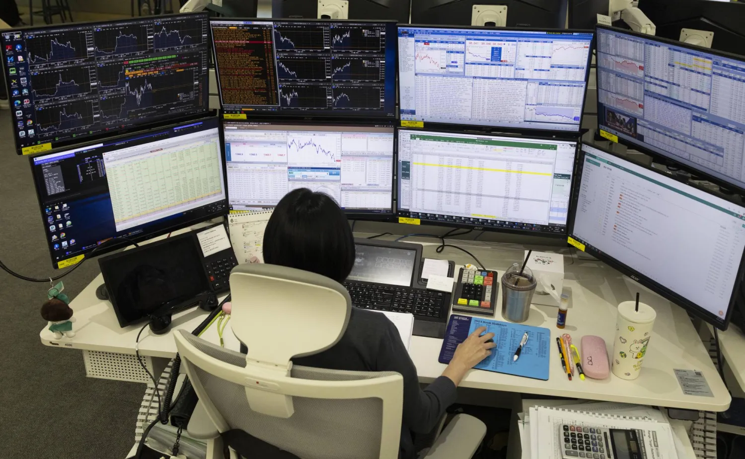 متداول أمام شاشة تعرض مؤشرات الأسهم في بنك هانا في سيول (إ.ب.أ) 