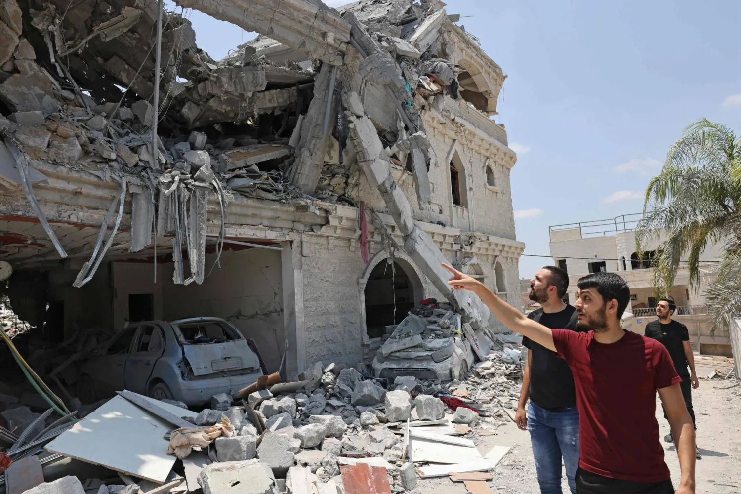 رجال يتفقدون الدمار الذي لحق بمنزل في مدينة طمرة شمال إسرائيل بعد الضربات الإيرانية (أ.ف.ب)