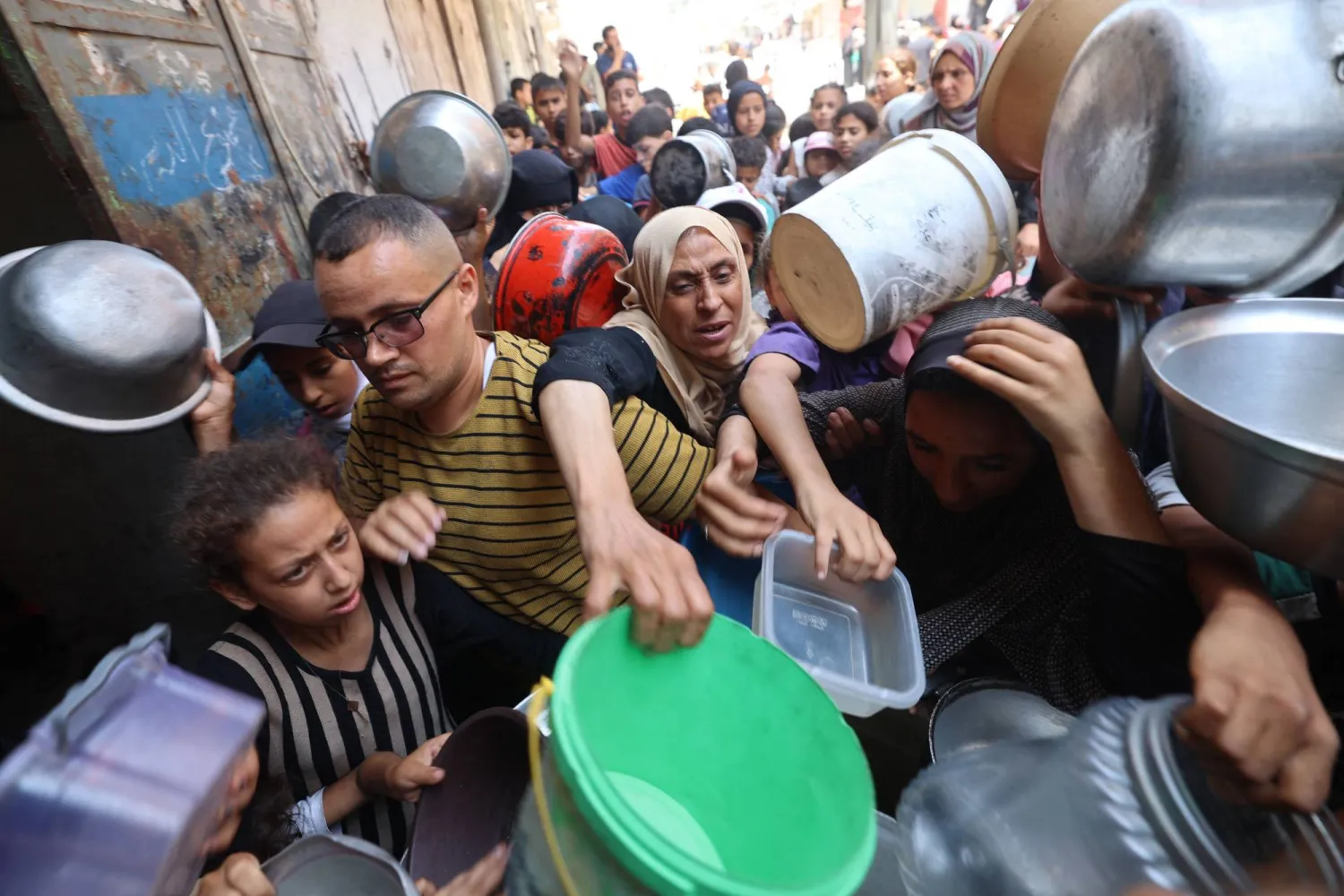 فلسطينيون يتدافعون عند نقطة توزيع المساعدات الغذائية في النصيرات وسط قطاع غزة (أ.ف.ب)