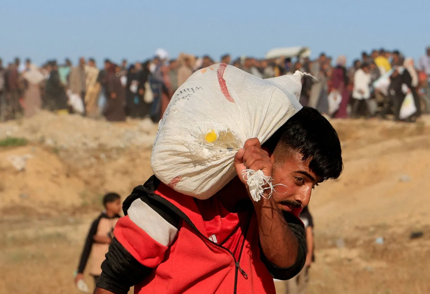 فلسطيني يحمل كيساً حصل عليه من «مؤسسة غزة الإنسانية» (رويترز)