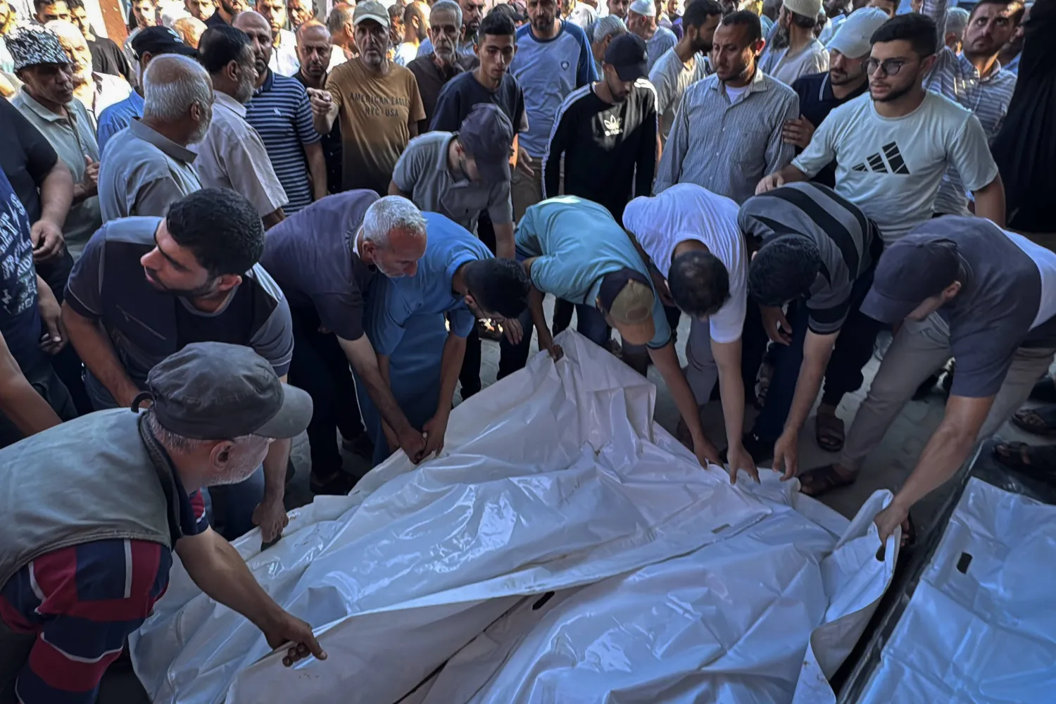 فلسطينيون يُجهّزون جثامين شهداء غارة إسرائيلية في مستشفى شهداء الأقصى بدير البلح في قطاع غزة (د.ب.أ)