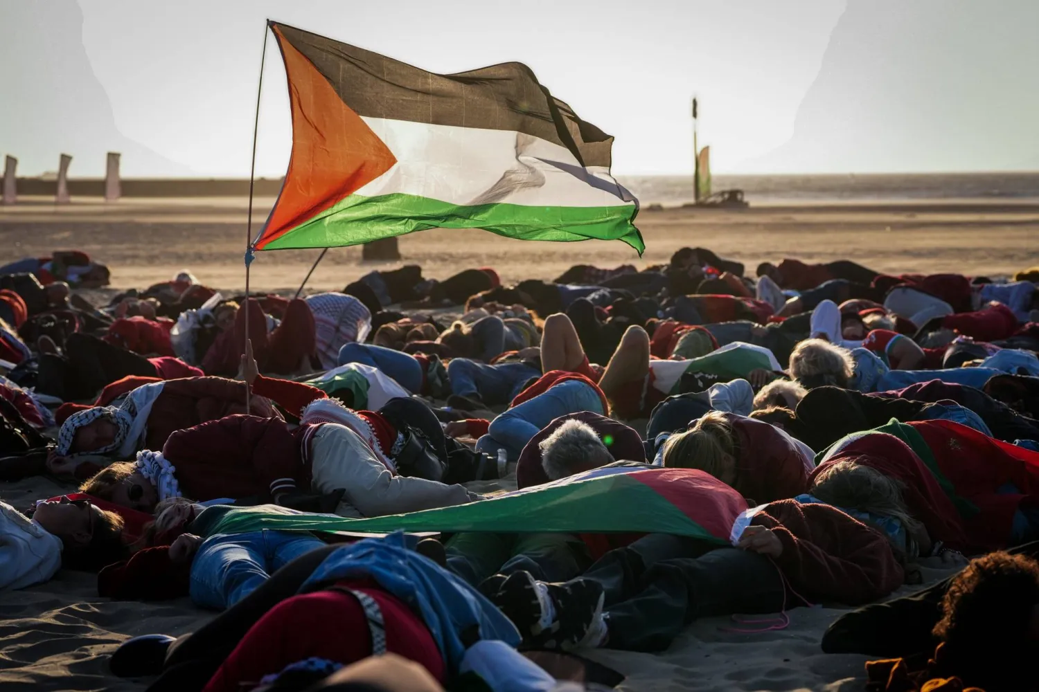 متظاهرون يرفعون العلم الفلسطيني الأربعاء في هولندا احتجاجاً على قمة (الناتو) في منتدى لاهاي (إ.ب.أ)