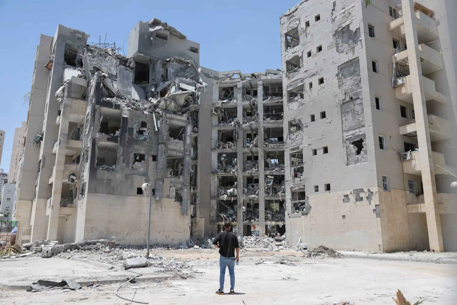 إسرائيلي يقف بالقرب من موقع ضربة صاروخية إيرانية أصابت منطقة سكنية في بئر السبع (إ.ب.أ)