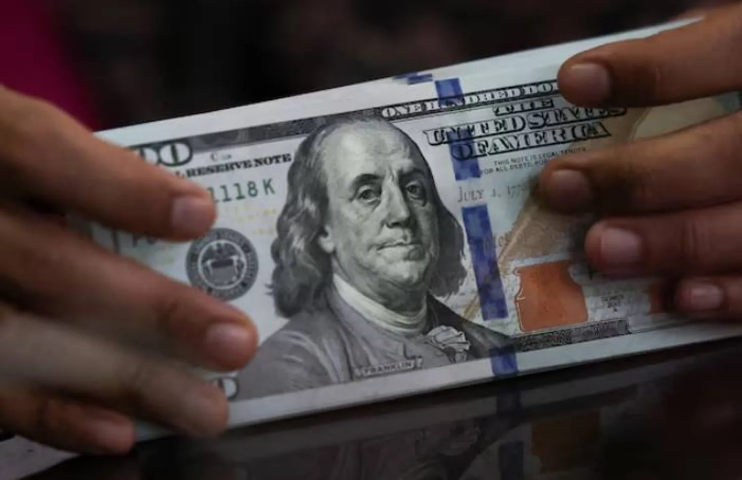 موظف يحمل أوراقاً نقدية من فئة الدولار الأميركي في مكتب صرافة بجاكرتا (رويترز)