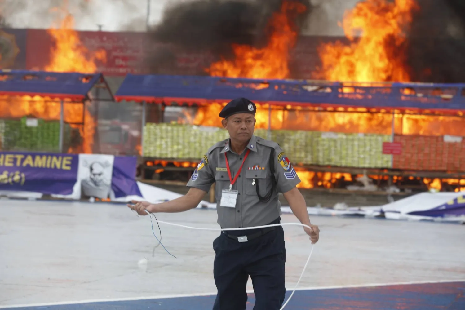 ضابط شرطة خلال «حفل إتلاف المخدرات المضبوطة» الذي أُقيم بمناسبة اليوم العالمي لمكافحة تعاطي المخدرات والاتجار غير المشروع بها في يانغون - ميانمار (إ.ب.أ)