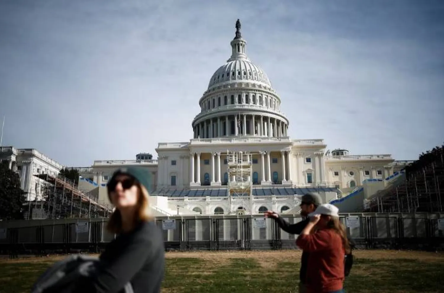 أشخاص يسيرون بجانب مبنى الكابيتول في واشنطن (رويترز)