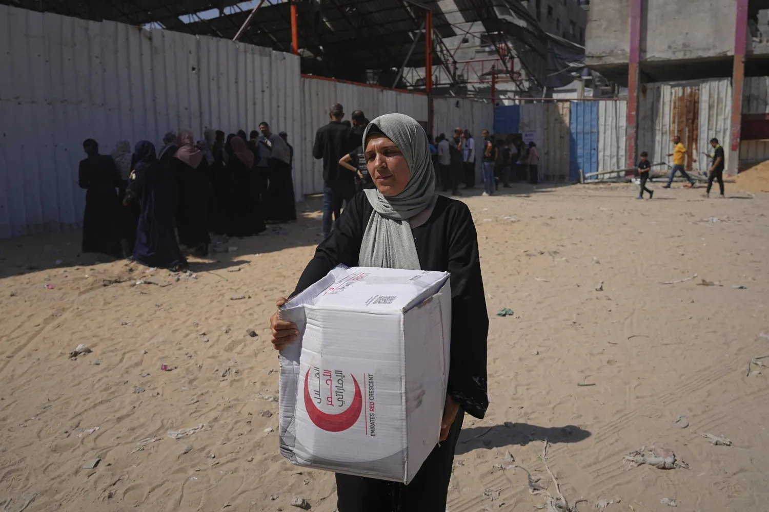 امرأة فلسطينية تحمل صندوق مساعدات في مدينة غزة (أ.ب)