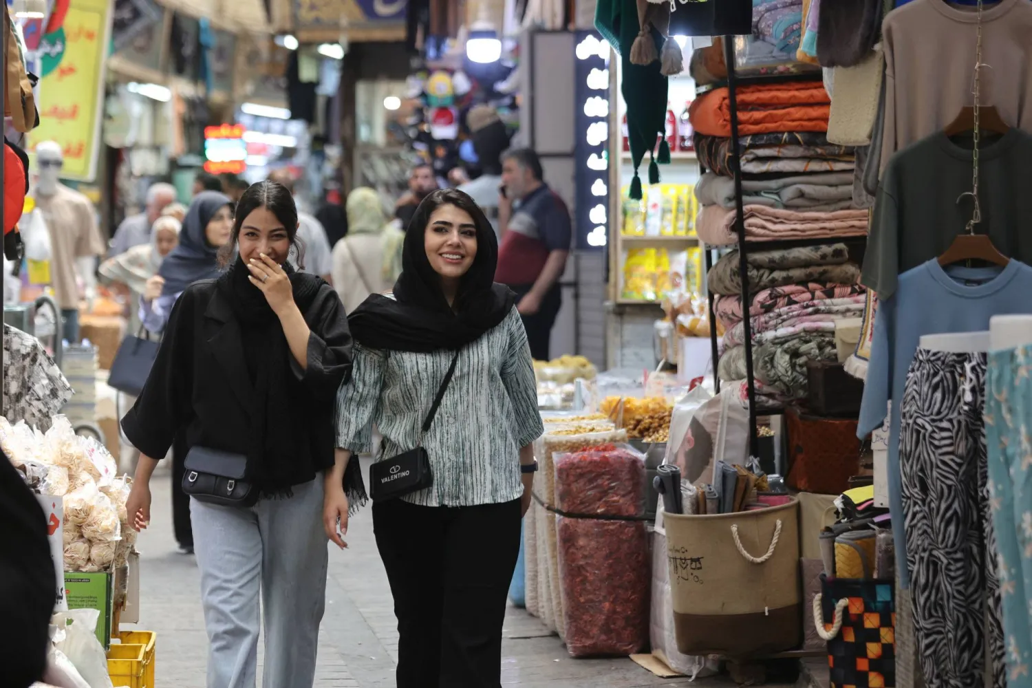 إيرانيتان تسيران في بازار تجريش بعد وقف إطلاق النار بين إيران وإسرائيل في شمال طهران الخميس (رويترز)