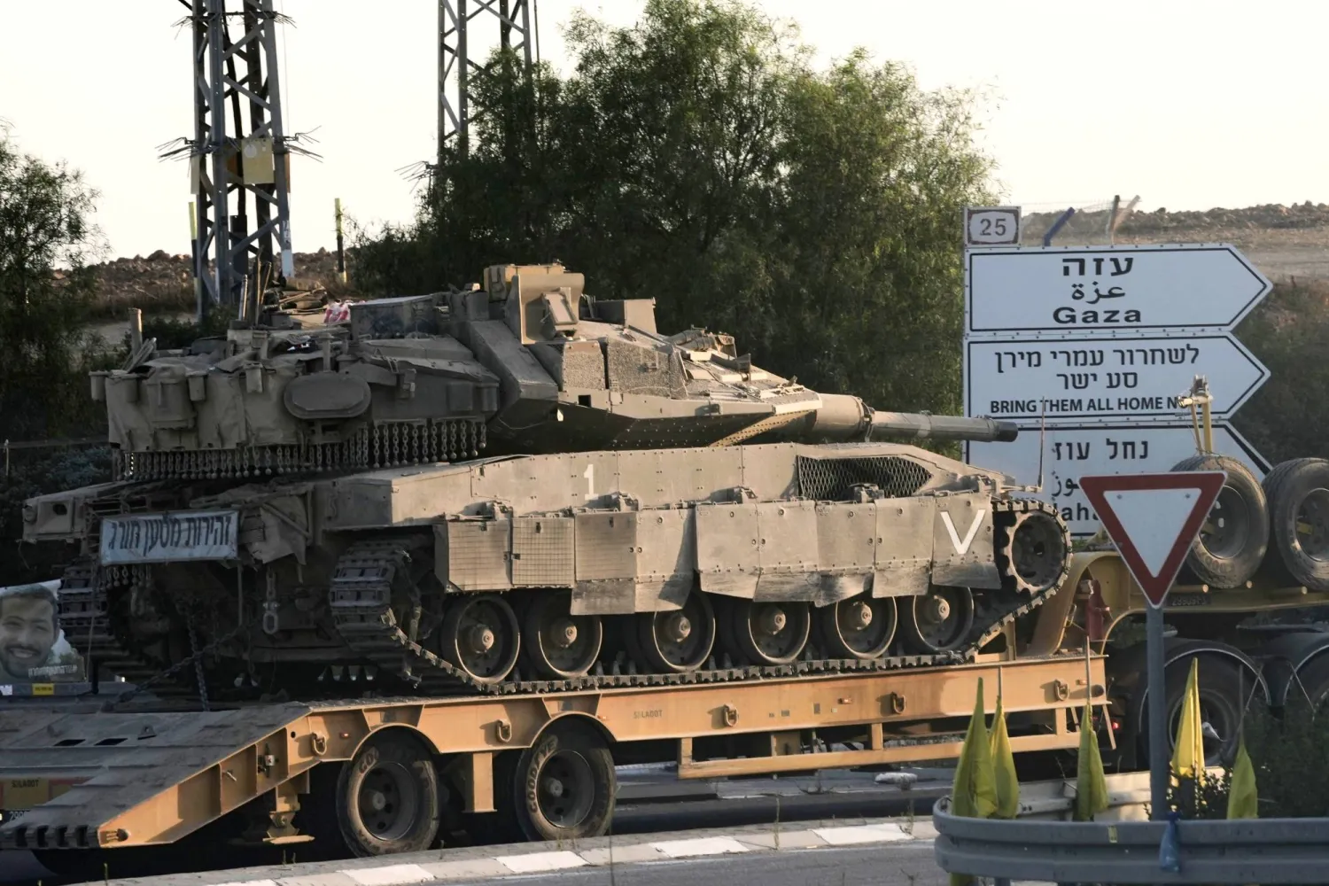 ناقلة تحمل دبابة إسرائيلية قرب الحدود مع قطاع غزة (أ.ب) 