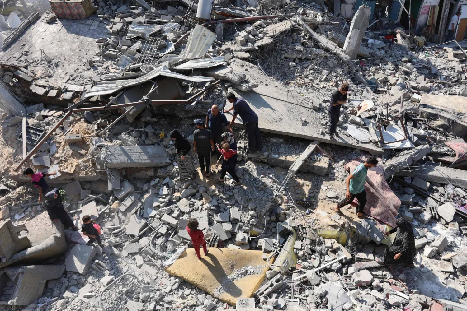 فلسطينيون في موقع غارة إسرائيلية على جباليا شمال قطاع غزة الجمعة (أ.ف.ب)