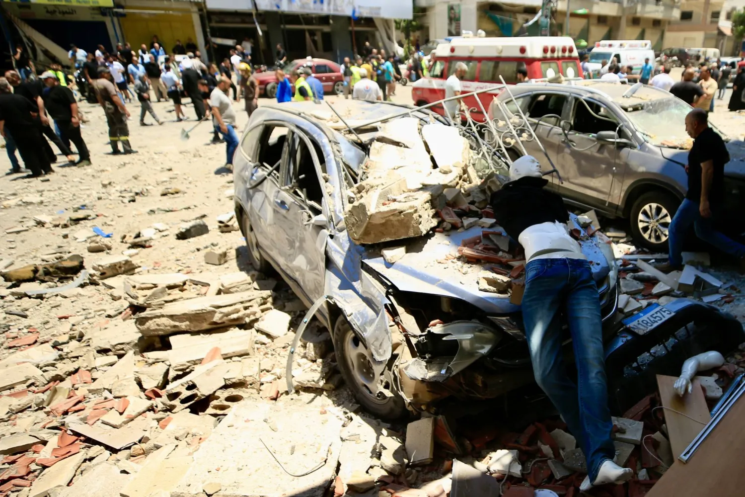 عناصر من الدفاع المدني إلى جانب سكان في موقع انفجار بالنبطية بجنوب لبنان (د.ب.أ)