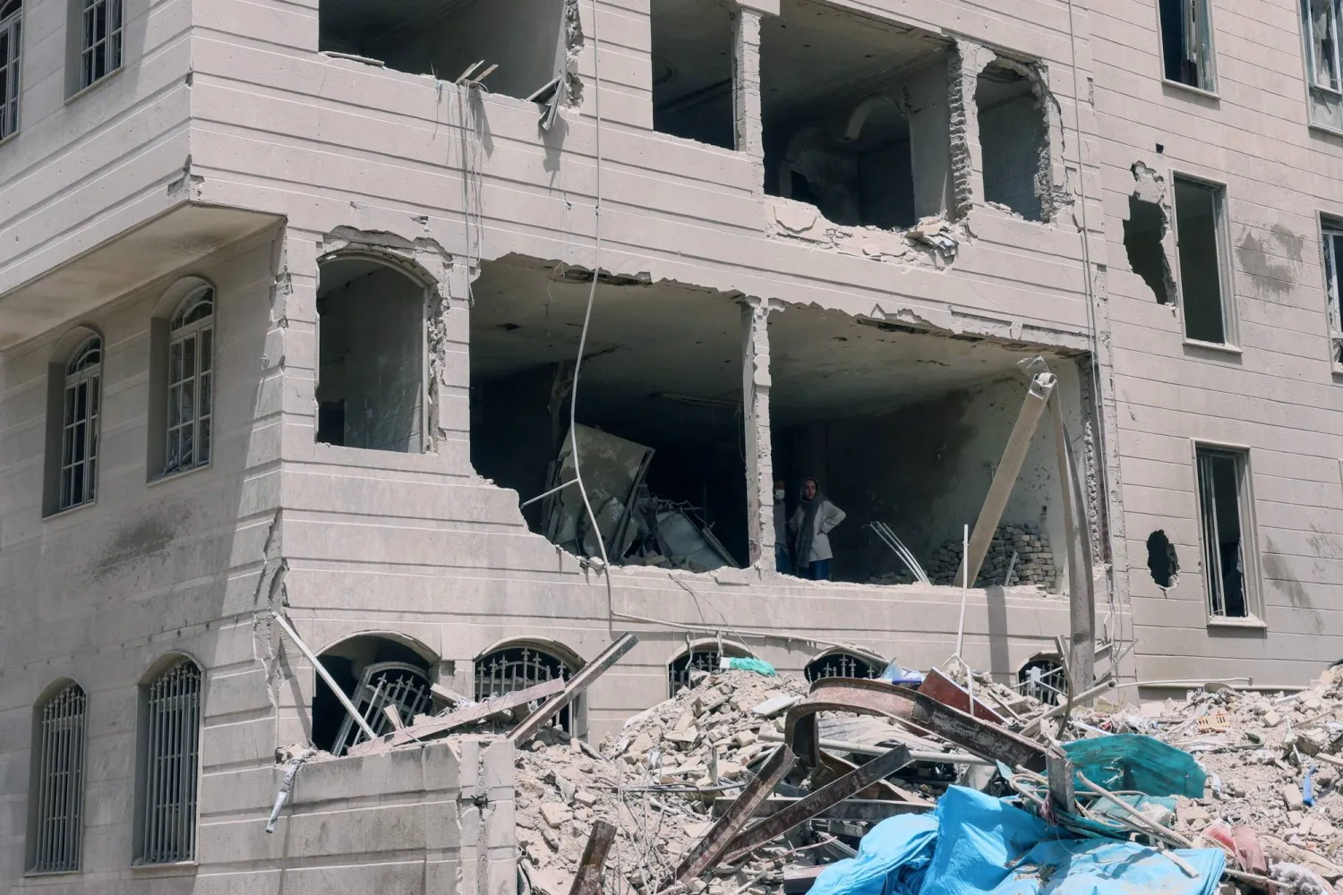 إيرانيون يتفقدون مبنى تضرر جراء الغارات الإسرائيلية على طهران (أ.ف.ب)