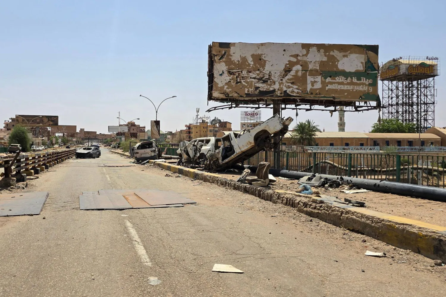 The wreckage of cars lie on the remains of the Shambat Bridge, which connects Omdurman and Bahri, on June 24, 2025 in the Sudanese capital region. (AFP)