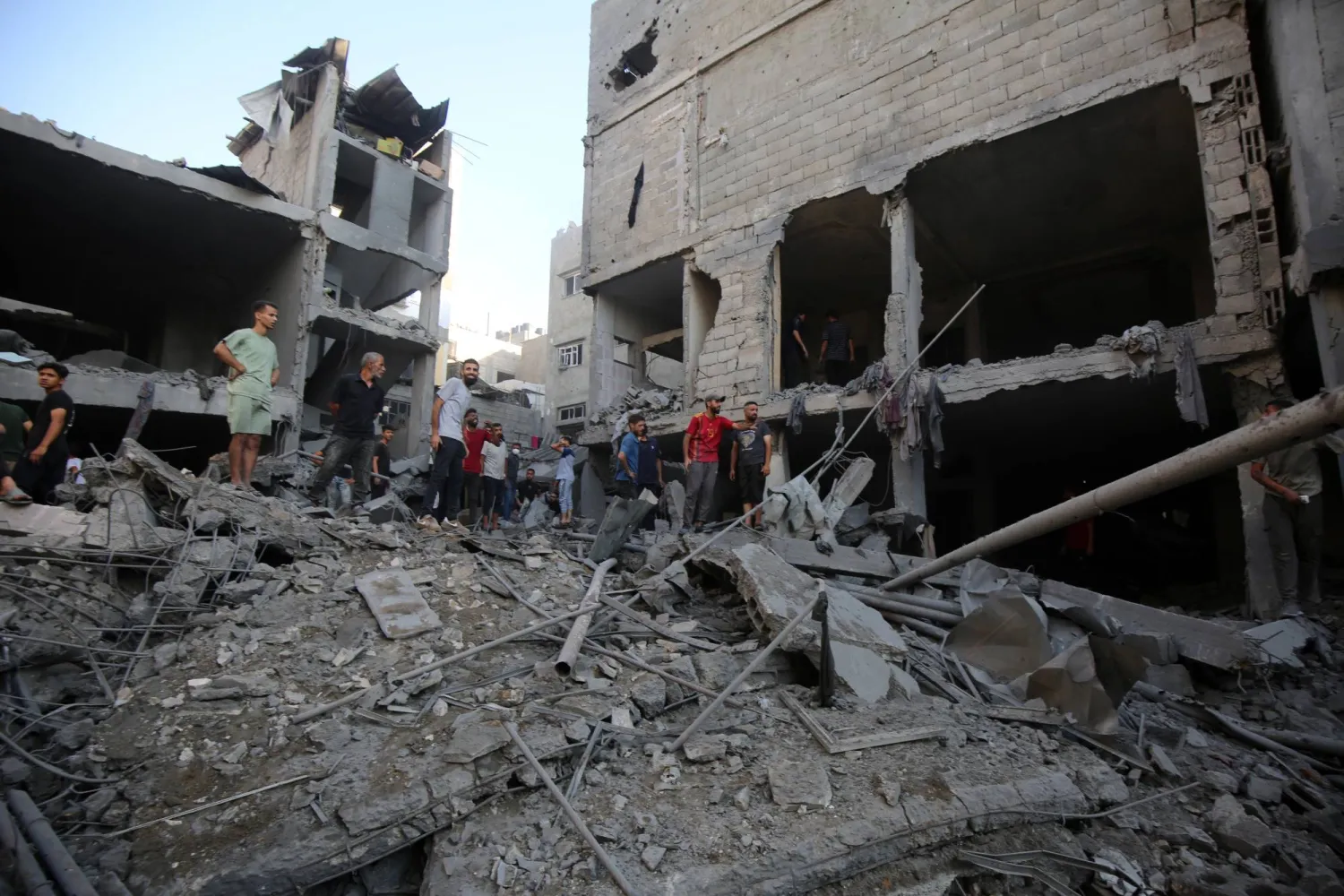 فلسطينيون يتفقدون الأضرار التي لحقت بمبنى سكني في مدينة غزة بعد غارة إسرائيلية (د.ب.أ)