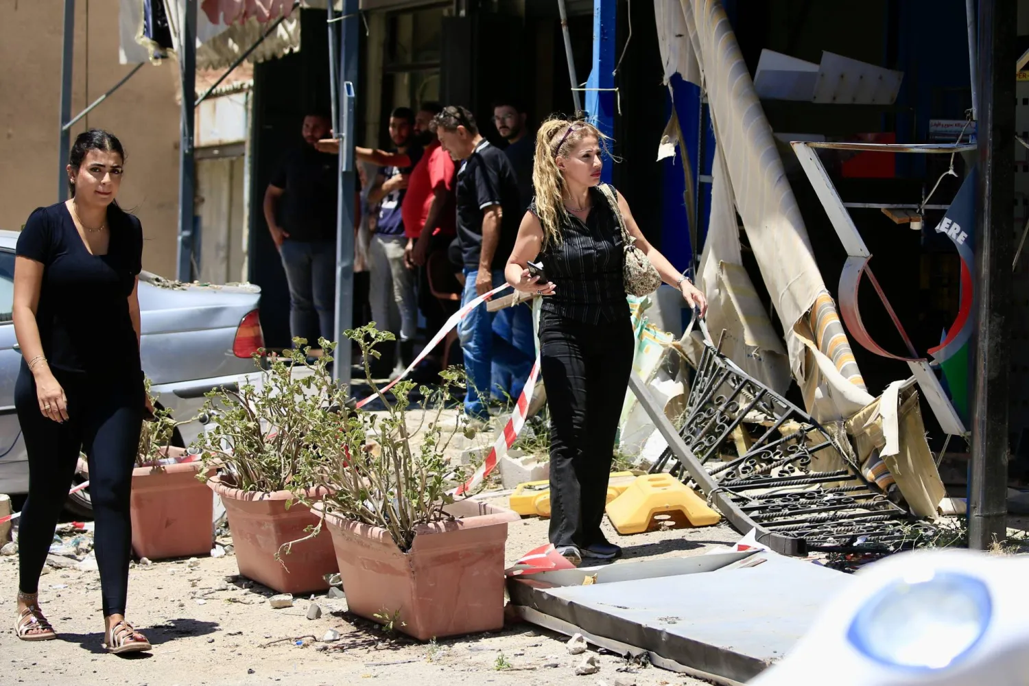 سكان محليون في موقع استهداف إسرائيلي في محيط مدينة النبطية بجنوب لبنان (إ.ب.أ)