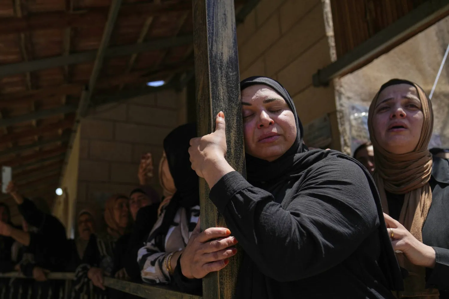 سيدتان فلسطينيتان تبكيان ضحية من ضحايا كفر مالك (أ.ب)