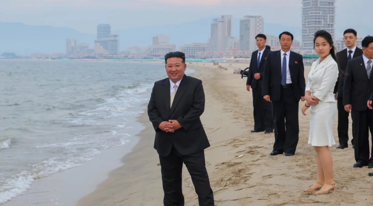 زعيم كوريا الشمالية كيم جونغ أون يقف على شاطئ منتجع «كالما» وخلفه ابنته كيم جو آي (وكالة الأنباء الكورية الشمالية)