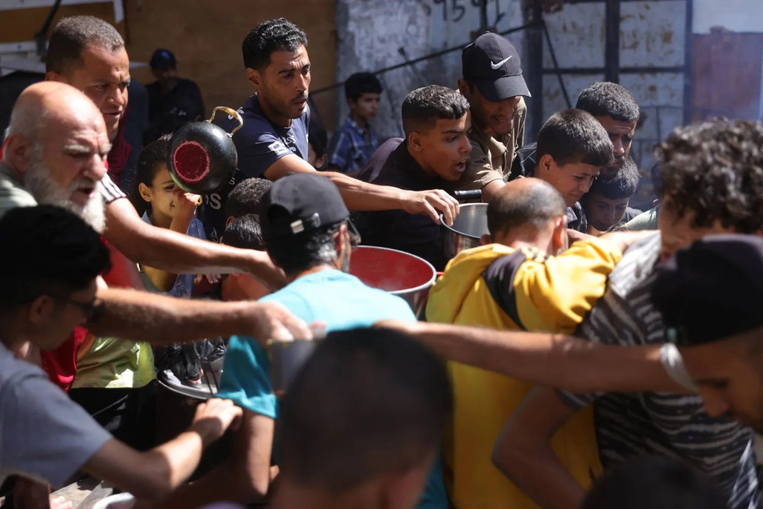 فلسطينيون أمام مركز لتوزيع المساعدات الغذائية في مدينة غزة يوم الجمعة (أ.ف.ب)