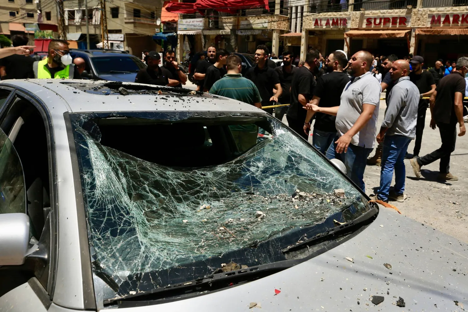 عمال الإنقاذ وسكان في موقع غارة إسرائيلية على مدينة النبطية بجنوب لبنان (إ.ب.أ)